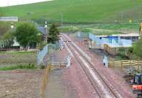 The site of Heriot station (1848-1969), photographed looking north from the bridge carrying the new road giving access to the village from the A7. The former level crossing has been replaced by a pedestrian subway, the eastern entrance to which is visible on the right. The old station building which stood to the north of the level crossing has been demolished. [See image 47184] <br><br>[John Furnevel 29/05/2015]