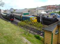 View from above the rear of the station signal box at Swanage on 13 May, with Standard Tank 80104 ready to depart platform 2 on the 14.00 service to Norden. BRCW 33201 is shut down attached to a coaching rake in the shorter platform 1, and Maunsell U class 2-6-0 31806 is stabled forward of the goods shed. <br><br>[David Pesterfield 13/05/2015]