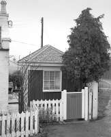 Loanstone level crossing box and surviving gatepost alongside the B7028, on the Peebles branch north of Pomathorn in April 1985. The sign on the gate reads <I>Loanstone Crossing</I>. The line closed completely in 1962.<br><br>[Bill Roberton 07/04/1985]