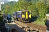 A summer evening service from Clitheroe to Manchester Victoria approaches Langho on 3 June 2015 as a small gathering awaits the arrival of <I>The Fellsman</I> [see image 51546].<br><br>[John McIntyre 03/06/2015]