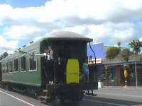 A friendly guard on The Bay of Islands Vintage Steam Railway, reversing on the train's return from Taumarere at Kawakawa, New Zealand, in March 2008. The track here runs along the middle of the road, hence the waving of the flag. Kawakawa is known locally as the train town<br><br>[Brian Smith 22/03/2008]