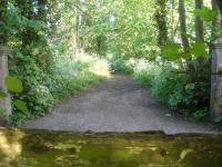 View along the Somerset & Dorset trackbed over the north side gate of the former Station Road level crossing [see image 51335] sited at Henstridge Station platform south end, with use still being made of the line solum to the south.<br><br>[David Pesterfield 12/05/2015]