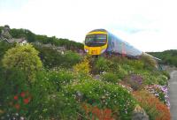 The 1325 TransPennine service to Barrow in Furness having just left Grange over Sands on 9th June 2015 passing above the colourful and well kept promenade of this lovely little town on the northern edge of Morecambe Bay.<br><br>[Brian Smith //]