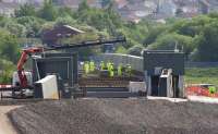 End on view looking east showing contractors working on the deck of the bridge structure on 12th June 2015. The degree of curvature of the steel bridge can be clearly seen from this angle.  The rectangular grey boxes are temporary cabins erected over the locations of the main welds to protect the welders from the elements.<br><br>[Colin McDonald 12/06/2015]