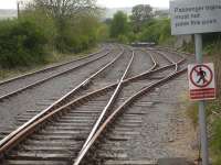 Looking west from the platform end at Redmire in May 2015, with the two loading sidings for Military Vehicles to and from Catterick Garrison on the right. The head-shunt is out of view round the curve, with the points for the platform line to join the loop just visible. [See image 6502] [Ref query 6607]<br><br>[David Pesterfield 25/05/2015]