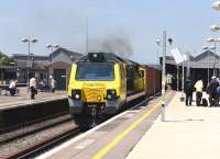 Freightliner 70014 makes its presence felt (and heard) as it accelerates an eastbound container train through the platforms of Didcot station on 11 June 2015.<br><br>[Peter Todd 11/06/2015]