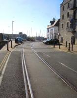 Looking west along Custom House Quay, Weymouth, on 12 May 2015. The single track of the disused former Weymouth Tramway is approaching St Edmunds Street overbridge (behind the camera) after rounding the curve from Commercial Road on its approach to the moribund Harbour Station.<br><br>[David Pesterfield 12/05/2015]