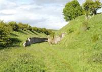 An interesting dry-stone walled cutting on the NER (SDLUR) route from Tebay to Kirkby Stephen, approx. 1 mile east of Ravenstonedale Station. Sandy Bank signal cabin was immediately west of this cutting and marked the transition from double track (west) to single (east), until 1931.</br><br>
Closed to regular passenger traffic in 1952,  heavy mineral trains continued until 1962 ensuring supplies of coke from the Durham coalfield to the Iron and Steel industry of Barrow and west Cumberland. Summer excursion traffic from Durham, Newcastle and Sunderland to Blackpool continued to be routed over  Barnard Castle, Stainmore, Kirkby Stephen and Tebay  until closure of the line. Additionally a Durham Miners Special ran once a fortnight conveying injured miners to convalesce at Conishead Priory.<br><br>[Brian Taylor 08/06/2015]