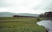 Looking north along the Clyde at Crawford under heavy skies in the summer of 1965. A Perth - Euston train has just crossed Crawford Viaduct hauled by EE Type 4 D337. <br><br>[John Robin 10/07/1965]