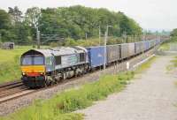 DRS 66303, with a Daventry to Coatbridge container service, runs north between the bridges at Elmsfield on 16th June 2015. The land in the foreground has been made into an engineers' access point with a ramp leading down from the bridge embankment.  <br><br>[Mark Bartlett 16/06/2015]