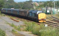 The Northern Trains 1736 Carlisle to Barrow service operated by Direct Rail Services leaves Dalston on 23 June 2015 on a rare sunny day. Fuel tankers at The Petroineos oil terminal occupy the background.<br><br>[Brian Smith 23/06/2015]