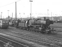 Old and (relatively) new rub shoulders at Oberhausen Osterfeld Sd shed in the Ruhr area of West Germany on Saturday 30th August 1975. The two more prominent class 50 2-10-0s, Nos. 050.489 and 050.056, were in their last year of operation but electric No. 140.247 on the left, originally classed as type E40, would survive well into the 21st century. Class E40 was once the standard medium powered electric freight loco on DB, extending to 879 units built between 1957 and 1973, but is now extinct.<br><br>[Bill Jamieson 30/08/1975]