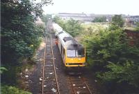 The driver climbs down from 60084 on 'Binliner' duties on the Powderhall Branch in July 1995. The view is towards Powderhall from the Dryden Terrace bridge. The right background has changed considerably over the last 20 years with housing on the former waste ground and the works demolished and built over. I should point out that the litter on the track must have been chucked from the overbridge as despite carrying nothing but landfill refuse the branch is mostly litter-free!<br>
<br><br>[David Panton 02/07/1995]