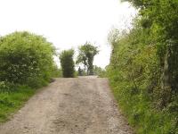 Looking west along Dolemoor Lane in Congresbury village across two former level crossings in close proximity. That on the crest nearest the camera was on the Wrington Vale Light Railway branch, whilst that in the distance was on the Cheddar Valley line. The cyclist is on the trackbed of the latter, now the combined national cycle route 26 and footpath.   <br><br>[David Pesterfield 10/05/2015]