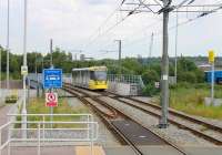 A tram bound for Ashton-under-Lyne crosses the M60 Motorway as it slows for the Hollinwood stop on the Oldham and Rochdale line. The bridge was put in by engineers building the motorway to carry Oldham line trains and now the Metrolink services. [See image 25756] for the same location in railway days.<br><br>[Mark Bartlett 01/07/2015]