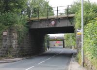 Warton Road at Carnforth, looking towards the town centre. The bridge in the foreground is now disused but once carried the direct link between the Barrow and Wennington lines. The second one carries the surviving, sharply curved, Wennington line out of Carnforth station. In between the two, Crag Bank Road off to the right goes under an even lower bridge [See image 50535] that carries the Carnforth - Barrow trains on the third side of the old triangle.  <br><br>[Mark Bartlett 06/07/2015]