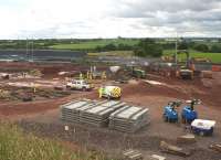 View south of the construction site from Brediholm Road on 8 July. Sleepers for the trackwork over the new bridge have started to arrive, and work is underway to remove the temporary embankments constructed on the north side of the line.<br><br>[Colin McDonald 08/07/2015]