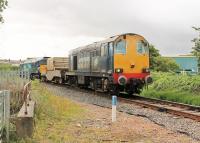 DRS 20305 approaches the boarded crossing at the start of the Heysham branch hauling a single nuclear flask and DRS 57301 <I>Goliath</I>, which had brought the train to Morecambe from Sellafield. 2015 was the last year of Class 20 operations on these flask trains. The blue building to the right of the Type 1 sits on the trackbed of the old line to Lancaster Green Ayre, most of which is now an urban cycleway. <br><br>[Mark Bartlett 08/07/2015]