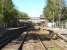 A view west through Sherborne Station from Gas House Hill level crossing on 12 May 2015. The main up side building stands beyond a now rare Southern Railway style fully roofed footbridge.<br><br>[David Pesterfield 12/05/2015]