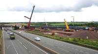 The new Bargeddie Bridge finally in position on 18th July 2015. There remain 8 days of line closure during which the track and OHLE will be reinstated. The excavation of the new M8 carriageway below the bridge spans will take place later and will not affect the railway. [See image 46140]<br><br>[Colin McDonald 18/07/2015]