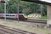 Pioneer <I>Voyager</I> 220001, on a Newcastle to Guildford Cross Country service, leaves York passing Holgate Junction. The large <I>running in board</I> on the embankment is seen from the steps of the Love Lane footbridge, which also crosses the Holgate Sidings lines in the foreground.  <br><br>[Mark Bartlett 18/07/2015]