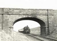 BR Standard class 3MT 2-6-0 77017 about to pass below Minnivey bridge with a northbound train shortly after leaving Dalmellington on 28 March 1959. The locomotive spent its entire life at Hurlford shed, having been delivered new from Swindon in 1954. It was withdrawn in November 1966 and broken up by T W Ward at Wishaw five months later. [Ref query 19422]<br><br>[G H Robin collection by courtesy of the Mitchell Library, Glasgow 28/03/1959]