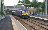 A Northern Electric service from Wigan to Liverpool on 15 July 2015, formed by one of the refurbished ex-Thameslink Class 319 EMUs, arrives at its first intermediate stop at Bryn.<br><br>[John McIntyre 15/07/2015]