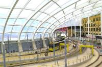 With major internal construction work complete, a Metrolink Service from Bury to Piccadilly heads out from Manchester Victoria Station on 24th July 2015 [see Image 49303].  The modern architectural style of the new roof makes a striking contrast with that of the original Lancashire and Yorkshire Railway headquarters. <br><br>[Malcolm Chattwood 24/07/2015]