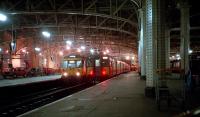 303023 prepares for a night departure from Glasgow Central's platform 11 in 1987. Recently arrived 318270 is in the neighbouring platform 10.<br><br>[Ewan Crawford 10/10/1987]