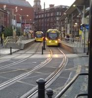 Saturday evening tram services crossing at Shudehill on 18 July 2015.<br><br>[Ken Strachan 18/07/2015]