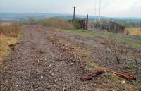 View south, in 1988, of the junction where the sidings for Pressed Steel left the Paisley and Barrhead District Railway. A loop was retained on the 'main line' at the junction which meant a stub beyond the point of divergence was retained. This had been the junction for the Inkerman Brick Works and before even that this area was served by the G&SWR's Linwood branch on a different alignment. The factory was taken over in the 1960s and expanded by Rootes becoming the car factory's North Plant. The photograph was taken at the time of demolition of the North Plant. [Ref query 32183]<br><br>[Ewan Crawford //1988]