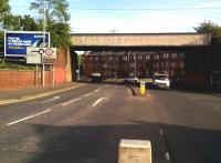 A picture that speaks volumes about changes from manufacturing to service industries, and about automotive traffic on the railways of Britain and beyond. The faded lettering on the bridge says <I>'TALBOT home of the Avenger and Sunbeam'</I>. The Linwood plant was opened as a Pressed Steel factory and built bodies for Glasgow's Blue Trains; then assembled Hillman Imps [see image 48344] and Hunters; then the Avenger and finally Sunbeam, until 1981. Kwik Fit boasts of its 44 year history on the hoarding on the left; but even the Transit van and pickup under the bridge have history with the railways. These were the last model built at the rail-served factory in Southampton. Transits are now built in Turkey. The previous dual sourcing arrangement led to a strange traffic flow, as each Transit plant only had press tools for one type of door. So Ford company trains took right hand doors from Southampton to Turkey, with a balancing flow of left hand doors from Turkey to Southampton. You couldn't make it up.<br><br>[Ken Strachan 14/07/2015]