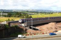 A Dalmuir - Whifflet service crosses the new bridge at Bargeddie on a sunny 7th August 2015. The distinctive steelwork of the original <I>Cutty Sark</I> bridge can just be seen on the left.<br><br>[Colin McDonald 07/08/2015]