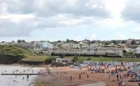 GWR 2-8-0T 5239 starts the climb to Churston on 25 July running behind the beach huts at Goodrington. The seven coach Paigton to Kingswear train includes a <I>Devon Belle</I> observation car. <br><br>[Mark Bartlett 25/07/2015]