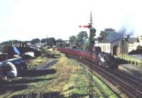 View north over Busby station from the signal box on a bright and sunny afternoon in 1961. A St Enoch - East Kilbride service is just about to leave behind a 2-6-4 tank.<br><br>[John Robin //1961]