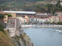 View across the bay towards the elevated Cerbere station, final station in France on the Perpignan to Barcelona Sants route, with a number of Bombardier built SNCF Ter Languedoc Roussillon Region 27500 class EMU sets in the station. The large interchange yard with RENFE is off picture to the left beyond the main running lines.<br><br>[David Pesterfield 30/07/2015]