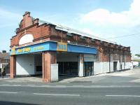 The white semi-circle over the entrance once displayed a rising sun accompanied by the words <I>'City of Carlisle Electric Tramways Company'</I>. The former Lindisfarne Street tram depot, looking north east across London Road in May 2003, at that time in use as a tool and equipment hire centre. [See image 9684] <br><br>[John Furnevel 13/05/2003]