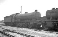 Final journey. Ex-NER Q7 0-8-0 63461 stands face to face with a WD Austerity in the works reception sidings alongside Darlington shed, thought to be in early 1963. All 15 of the powerful Q7s had been withdrawn from Tyne Dock shed in November and December 1962 following their replacement by BR Standard class 9F 2-10-0s on the Tyne Dock - Consett iron ore trains. 63461 was cut up in North Road scrapyard during March 1963. [See image 23722]<br><br>[K A Gray //1963]