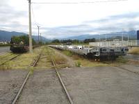 Looking east over the former goods yard at St-Jean-Pla-de-Corts, beyond Le Boulou, on the now freight only branch from Elnes that continues, albeit abandoned from approx 750m beyond the yard, to Ceret station site. The yard contains two rakes of piggyback wagons stabled either side of the through line. Those on the left carry the Lorry Rail legend, whilst those on the right are brand new LOHR Industries wagons, still with the transit label attached. In the distance, beyond the yard, is a further rake of mixed bogie wagons stabled up to a large concrete stop block on the remaining section of operational line. [See image 53120] for view in opposite direction. <br><br>[David Pesterfield 01/08/2015]