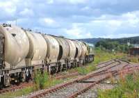 A Freightliner Heavy Haul service of cement empties prepares to depart for Oxwellmains from an increasingly weed-encroached Millburn Yard in Inverness on 28th August 2015.<br><br>[David Spaven 28/08/2015]