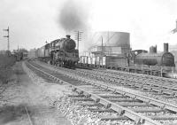 BR Standard Class 4 2-6-0 no 76100 on a Balloch to Carmyle train in April 1958. Caley 'Jumbo' 57314 is standing in the Gasworks siding with mineral wagons.  <br><br>[G H Robin collection by courtesy of the Mitchell Library, Glasgow 12/04/1958]