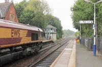 Three lines once radiated from Romiley Junction but the link to Stockport Tiviot Dale is now closed. The remaining two lines to Manchester are busy though with four passenger trains an hour each way plus freight workings. 66076 powers through Romiley on 1 September in a sudden downpour, taking the Hyde line with a stone train from Briggs Sidings at Hindlow to Ashburys. The line to the left runs through Reddish North. <br><br>[Mark Bartlett 01/09/2015]