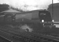 Never an easy location for a photograph, even on a bright and sunny day, Nottingham Victoria in rain and mist presented something of a challenge. Saturday 30 March 1963 was such a day, with unrebuilt Battle of Britain Pacific 34054 <I>Lord Beaverbrook</I> adding to the atmosphere as it arrives through the murk with one of several inter-regional football excursions bringing fans from Southampton via the Great Central line. <br><br>[K A Gray 30/03/1963]