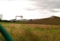 Latest DIRFT developments north of the bridge over the A428 in early September 2015. [see image 52348]. The Sainsbury's warehouse is visible on the left. Notice the stack of containers and the new container crane left of centre. A 'super shunter' like 37714 (centre) can be seen here most weekday afternoons. To the right, the embankment has been extended towards the proposed crossing of the A5.<br><br>[Ken Strachan 04/09/2015]