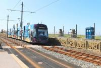 <I>Running the gauntlet at Bispham</I>. Flexity 016 slows for the Bispham stop as it passes a couple of sinister onlookers. The large illuminated tableaux start at this point and stretch down to the Cabin area of Blackpool. <br><br>[Mark Bartlett 12/08/2015]