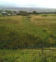 View North West down Clee Hill towards Clee Hill Junction, where the mineral line joined the Shrewsbury to Hereford railway. The standard gauge adhesion worked line ran through the clump of trees in the background, along the darker section of field, and under the road on which the photographer is standing, to a terminus named Clee Hill. There were standard gauge sidings on the left of the main line, allowing interchange with both narrow and standard gauge rope worked inclines. [see image 52460]<br><br>[Ken Strachan 26/08/2015]