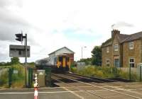 A westbound train passing the site of Low Row station, between Haltwhistle and Brampton, on 17 July 2015. The DMU has just passed the new signal box built in 2009 to replace the original which stood behind the camera alongside the level crossing [see image 36655]. [Ref query 368]<br><br>[Ken Strachan 17/07/2015]