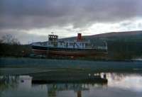 The MV <i>Countess Fiona</i> on the maintenance slipway at Balloch Pier. She was built by William Denny in 1936 and was originally the <i>Countess of Breadalbane</i> operating on Loch Awe, moved overland to Loch Fyne in 1952, renamed <i>Countess of Kempock</i> in 1971 and finally became <i>Countess Fiona</i> when moved to Loch Lomond in 1982. Her back was broken by a derailment caused by vandals and she was scrapped on site in 1999 after lying derelict for several years. The view is from the railway pier.<br><br>[Ewan Crawford //1987]