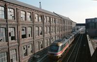 A southbound HST passes through the man made canyon to the north of Arbroath station in 1996. The Westburn Works (jute, hemp, flax) spanned both sides of the line at Wellgate. The building to the left has since been demolished and the site is now a supermarket.<br><br>[Ewan Crawford //1996]