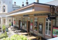 Kingswear station feels like it has been <I>shoe horned</I> into the narrow strip of land between the River Dart and the steep hillside. The old station building is in good repair and used by the steam railway and this restaurant, seen from the road leading to the ferries.<br><br>[Mark Bartlett 31/07/2015]